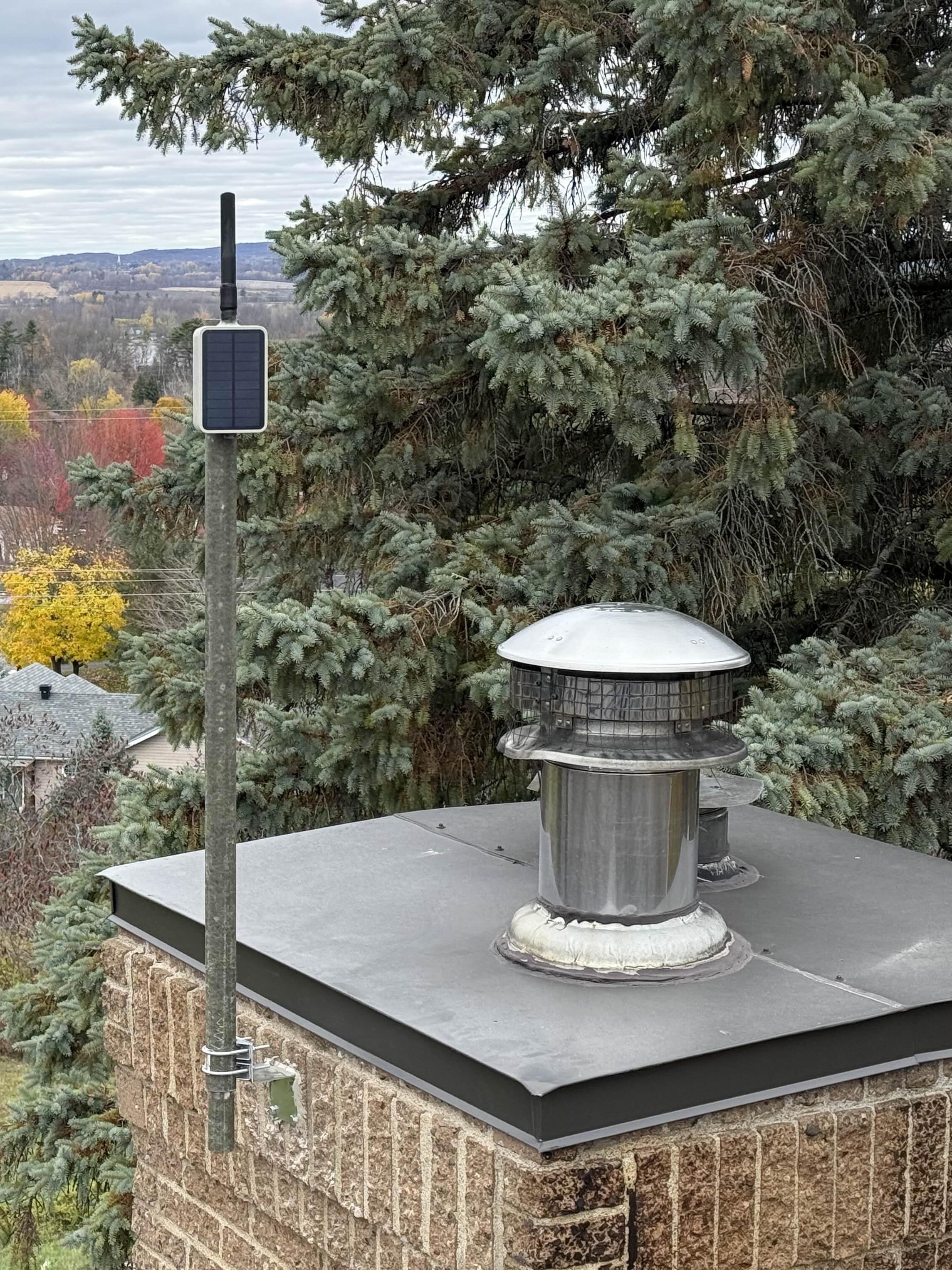 A community example of a repeater pole attached near a chimney